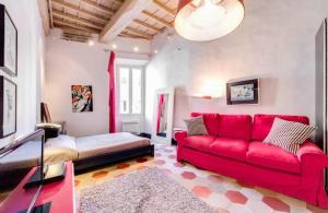 a living room with a red couch and a table at 5 scole apartments in Rome