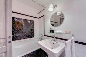 a white bathroom with a sink and a tub and a mirror at 5 scole apartments in Rome