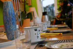 einem Holztisch mit Tellern und Gläsern darauf in der Unterkunft Au Domaine du Cerf in Vyans