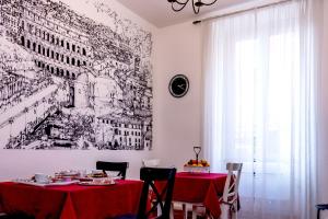 a dining room with a red table and a drawing on the wall at Monticello apartment via Cavour in Rome