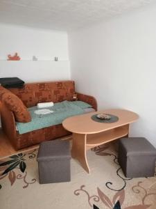 ein Wohnzimmer mit einem Sofa und einem Tisch in der Unterkunft Nagymackó Kuckója in Keszthely