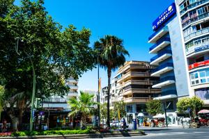 a city street filled with palm trees and palm trees at Hotel Monarque El Rodeo in Marbella