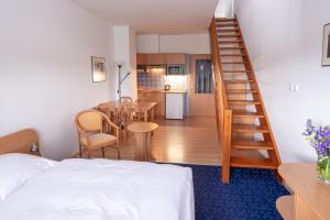 a room with a bed and a kitchen with a staircase at Apartmány Engadin in Boží Dar