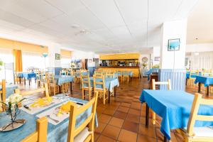 une salle à manger avec des tables et des chaises bleues dans l'établissement Hotel du Port, à Canet