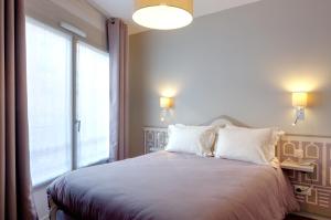 a bedroom with a bed with a large window at Hôtel Ours Blanc - Wilson in Toulouse
