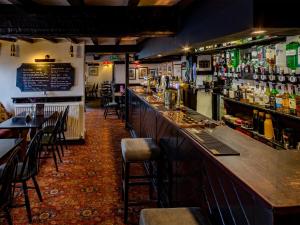 a bar in a restaurant with tables and chairs at The Barrel Inn in Eyam