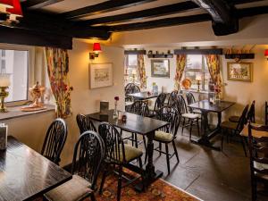 a restaurant with tables and chairs in a room at The Barrel Inn in Eyam
