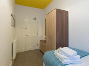 クルーにあるTownHouse @ West Avenue Creweのベッドルーム1室(ベッド1台付)、木製キャビネットが備わります。
