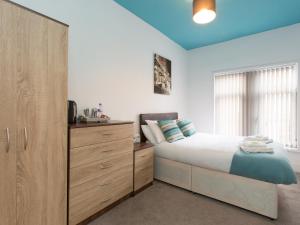 a bedroom with a large bed and a dresser at TownHouse @ West Avenue Crewe in Crewe
