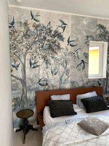 a bedroom with two beds and a wall with birds at Haus der Schwalbe in Oberhofen am Thunersee