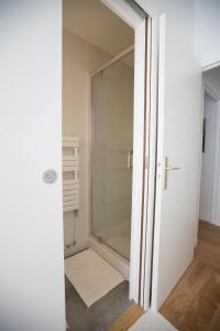 una puerta de cristal que conduce a una ducha en el baño en L'Aubertine en Beaune