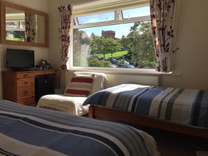 1 Schlafzimmer mit 2 Betten und einem Fenster in der Unterkunft Barbican Reach Guest House in Plymouth