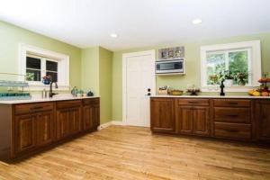 a kitchen with green walls and wooden cabinets at Bark Eater Inn in Keene