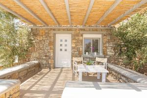 a patio with a wooden pergola and a table at Overview Mykonos Apartments in Mýkonos City