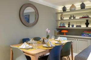 a dining room table with chairs and a mirror at Beaches Brighton - Luxury Seafront Accommodation in Brighton & Hove