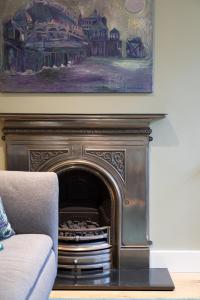 a fireplace in a living room with a painting at Beaches Brighton - Luxury Seafront Accommodation in Brighton & Hove