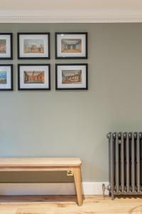 a room with a bench and framed pictures on a wall at Beaches Brighton - Luxury Seafront Accommodation in Brighton & Hove