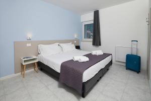 ナーゴ・トルボレにあるAppartamenti Villa al Fiumeのベッドルーム1室(大型ベッド1台、青いスーツケース付)