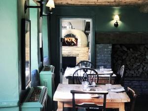 a dining room with a table and a pizza oven at The Bell Inn in Lechlade
