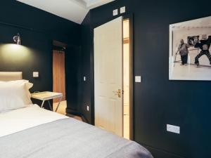 1 dormitorio con cama blanca y pared azul en The Bell Inn en Lechlade