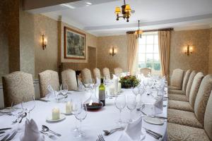 a dining room with a long table with wine glasses at Cavendish Hotel in Baslow