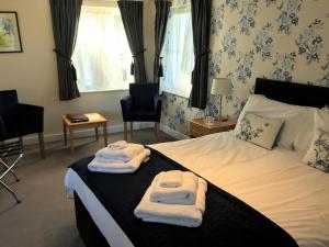 a hotel room with a bed with towels on it at The Bird in Hand in Ashwellthorpe