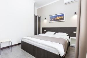 a bedroom with a large bed with white sheets at Khreshchatyk - Independence Square Apartments in Kyiv
