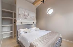 a bedroom with a white bed with two pillows on it at Martinela Villas Istria - Villa Franko in Rojnići