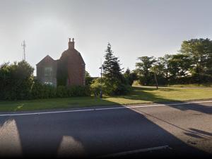 a house sitting on the side of a road at BlackbullA1lodge in Grantham