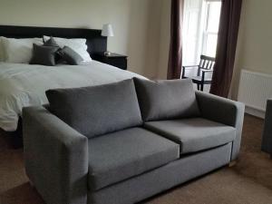 a bed and a couch in a bedroom with a bed at The Blackbull Inn Polmont in Polmont