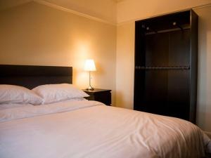 a bedroom with a large white bed and a lamp at The Blackbull Inn Polmont in Polmont