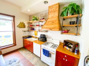 a kitchen with a white stove top oven next to a window at ITH Adventure Hostel San Diego in San Diego
