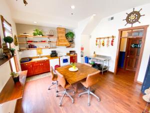 a kitchen with a wooden table and a wooden floor at International Travelers House Adventure Hostel in San Diego