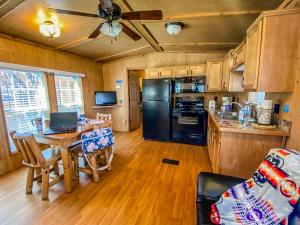 a kitchen with a table and a black refrigerator at Healing Waters Resort and Spa in Pagosa Springs