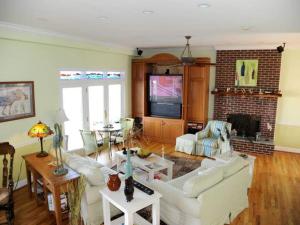 a living room with a white couch and a tv at Blue Heron Inn - A Bed and Breakfast LLC in Solomons