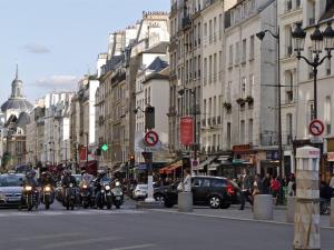een groep motorfietsen die door een drukke stadsstraat rijden bij Blue Nights Sébastopol 110 in Parijs