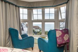 2 chaises bleues assises devant une fenêtre dans l'établissement Bosanneth, à Falmouth