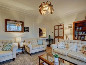 a living room with couches and a chandelier at Bosavern House in St Just