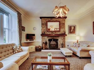 a living room with a couch and a fireplace at Bosavern House in St Just