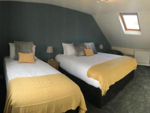 1 dormitorio con 2 camas y mantas amarillas en Botley Townhouse en Oxford