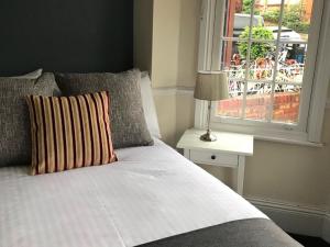 a bedroom with a bed with a window and a lamp at Botley Townhouse in Oxford