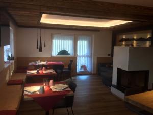 a living room with two tables and a fireplace at B&B DeBy & E-Bike Rental in San Niccolò Comèlico