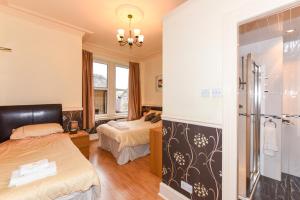 um quarto de hotel com duas camas e um chuveiro em Brae Guest House em Edimburgo
