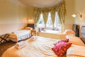 una camera con tre letti e una finestra di Brae Guest House a Edimburgo