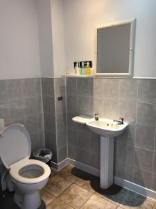 a bathroom with a toilet and a sink at Breeze Guest House in Bootle