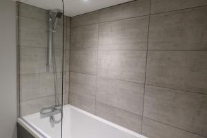 a bathroom with a shower with a tub and a sink at BrickSage Rooms, King's Lynn The Walks in King's Lynn