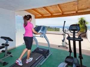 Una donna sul tapis roulant in palestra di Parco Residence La Rosa a Ischia