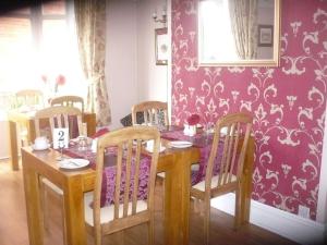 una mesa de comedor y sillas con una pared púrpura en The Broadfield, en Bridlington