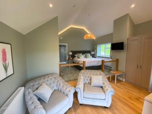 a living room with two couches and a bed at Pen-Y-Dyffryn Country Hotel in Oswestry