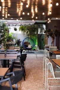 un restaurant avec des tables, des chaises et une balançoire dans l'établissement Hotel Parati Minas, à Uberlândia